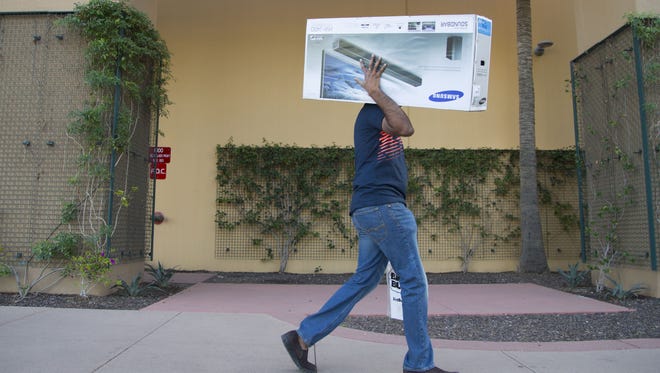 Raj Nimmalagadda carries his shopping items back from Best Buy during the second busiest shopping day of the year at Tempe Marketplace on Dec. 19, 2015 in Tempe, Ariz. It was so busy he had to park far away and carry his items all the way back to his car.