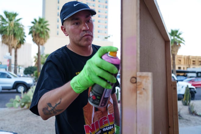 Artist Nazario Sandoval spray paints a canvas during the First Friday art walk in downtown Phoenix on Aug. 4, 2023.