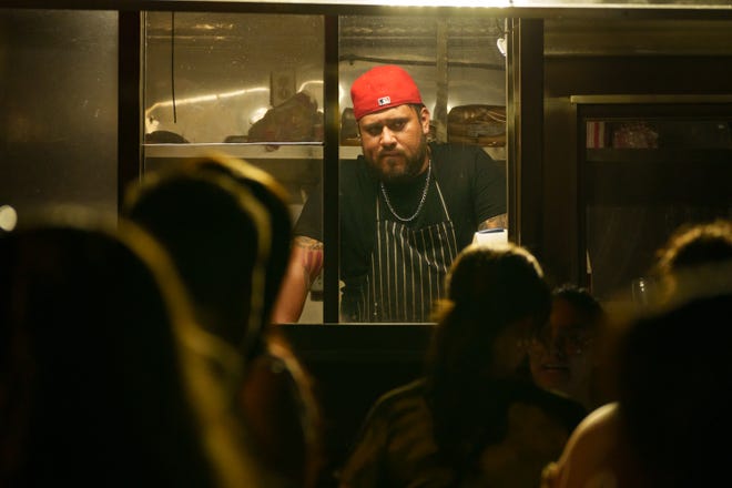 Alejandro Flores looks out to the customers while working in a food truck for the First Friday art walk in downtown Phoenix on Aug. 4, 2023.