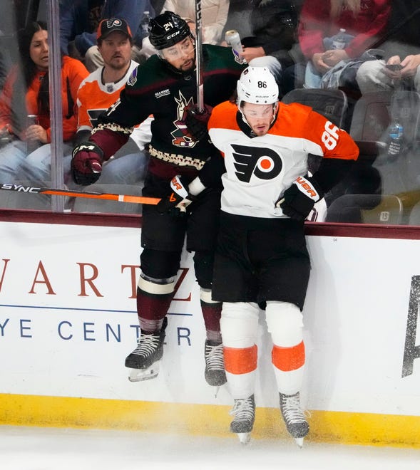 Arizona Coyotes defenseman Matt Dumba (24) is checked into the boards by Philadelphia Flyers left wing Joel Farabee (86) in the first period at Mullett Arena.