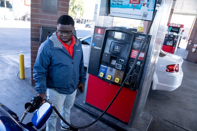 Ty Rodgers fills their car with gas at a QuickTrip gas station on Thomas Road near 24th Street in Phoenix on Dec. 8, 2023.