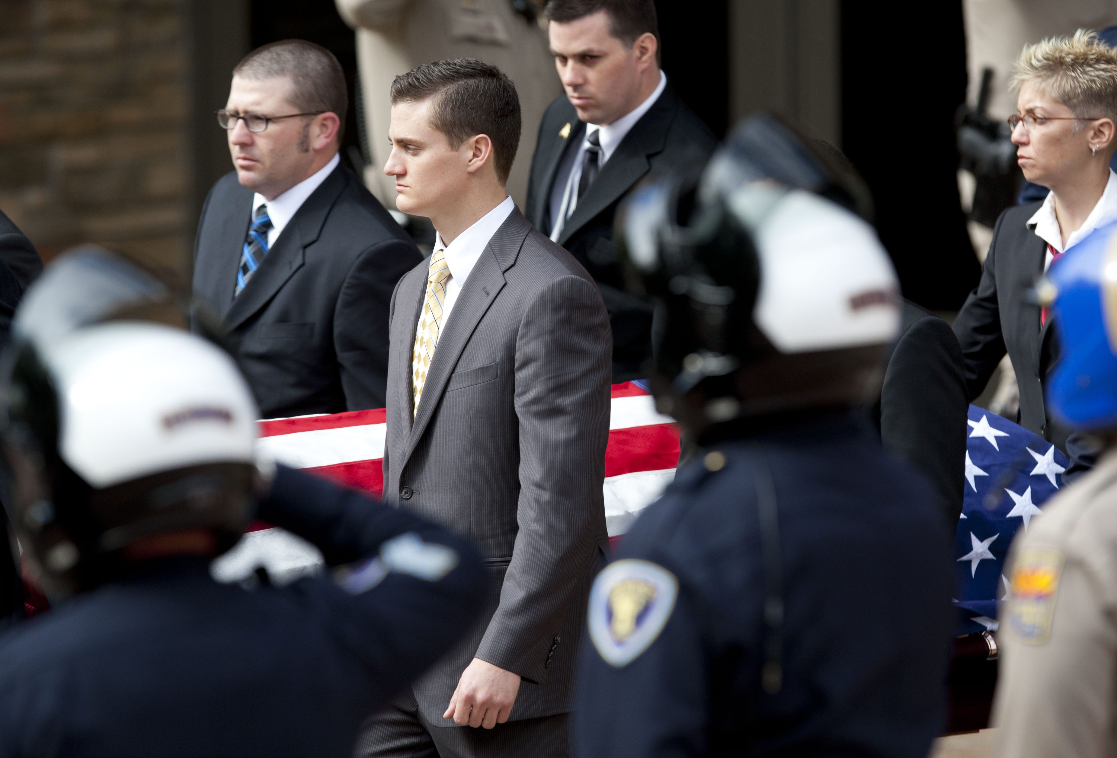 One of Bradley Jones' brother (center-left) pushes the flag-draped casket of fallen Glendale Police Officer Bradley Jones during the recessional for the funeral service of Glendale Police Officer Bradley Jones at Christ's Church of the Valley in Peoria on Friday, November 4, 2011.