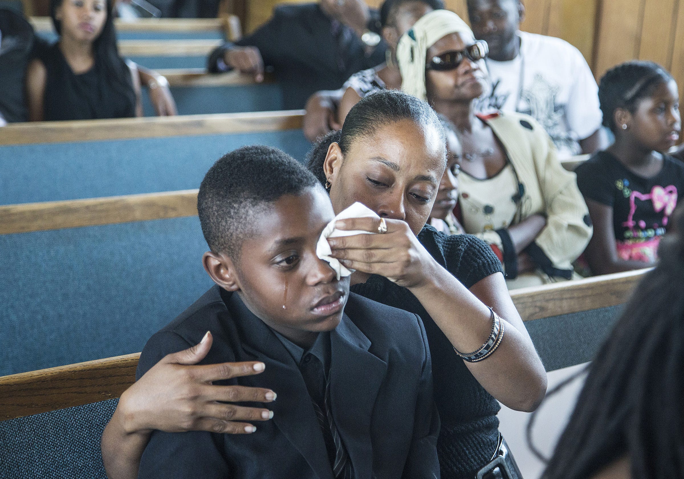 Sharon Lamb with her son Kasai Hayden, 10, extended family of deceased Michelle Cusseaux, mourns their loss during the funeral services at Emmanuel Church Of God In Christ in Phoenix, on August 23, 2014. Cusseaux was fatally shot by Phoenix police.